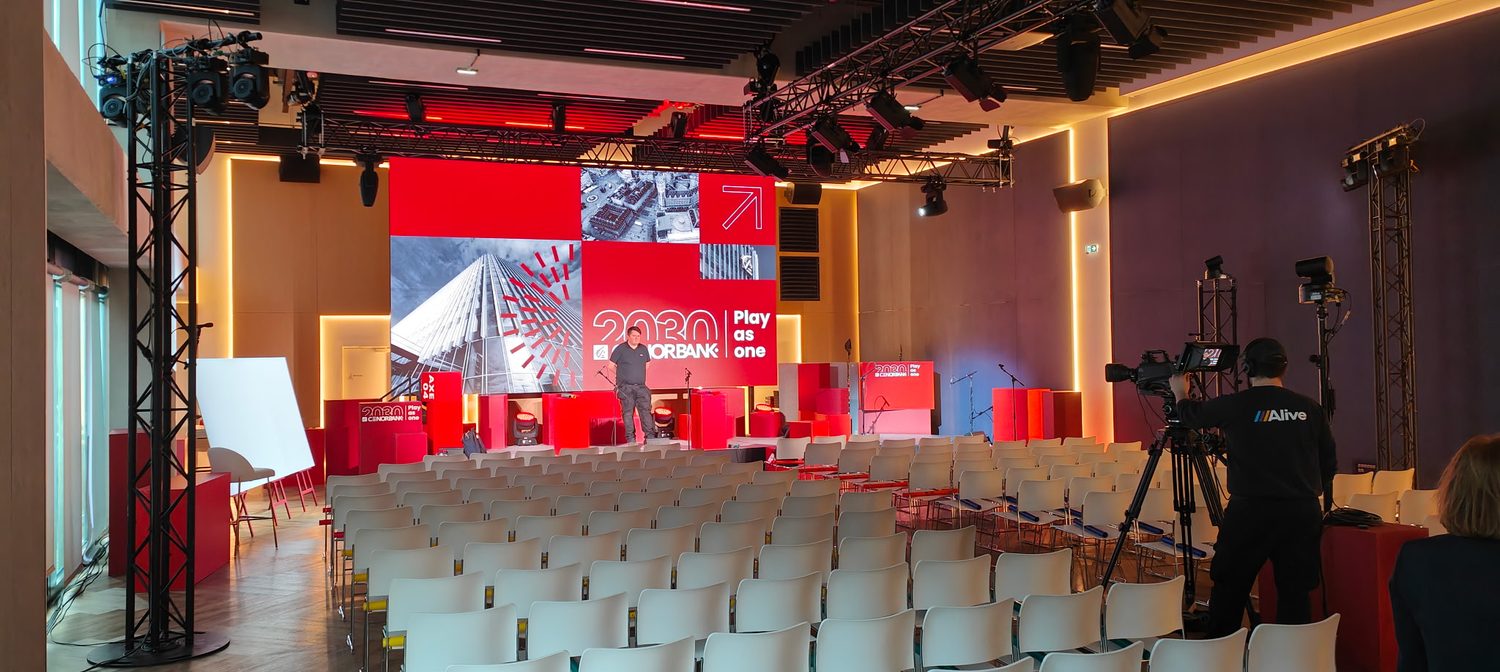 Salle en configuration conférence, rangées de chaises face à la scène
